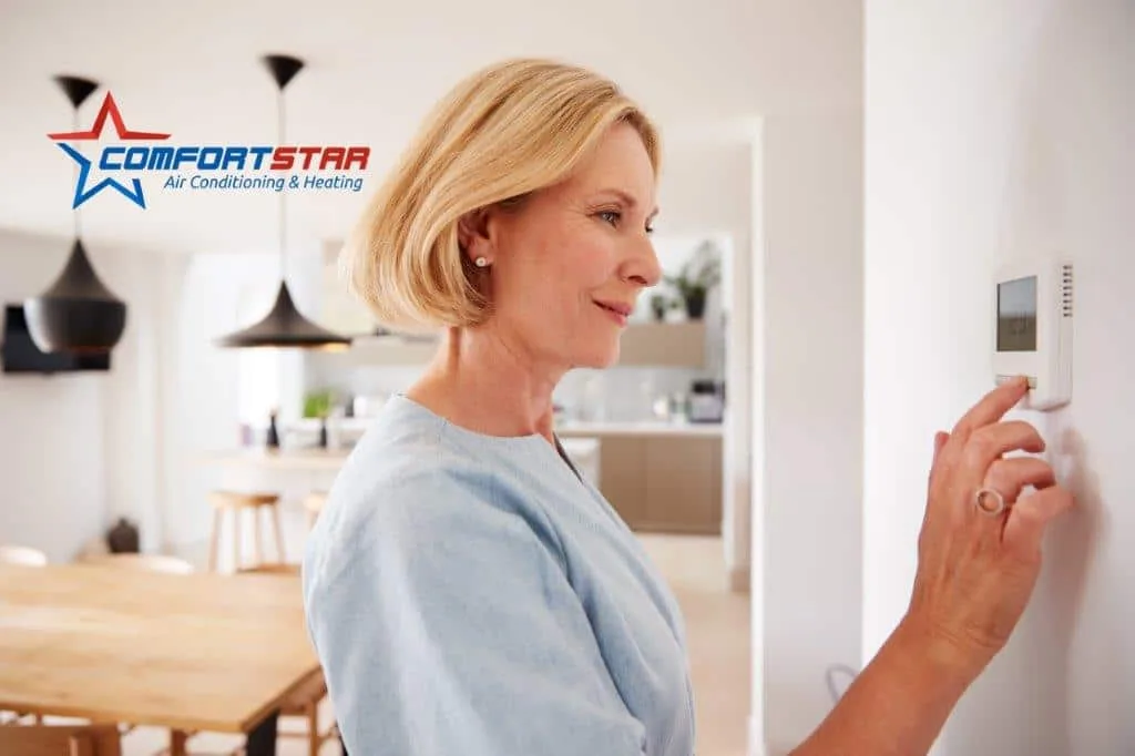 Homeowner is adjusting the residential AC Thermostat